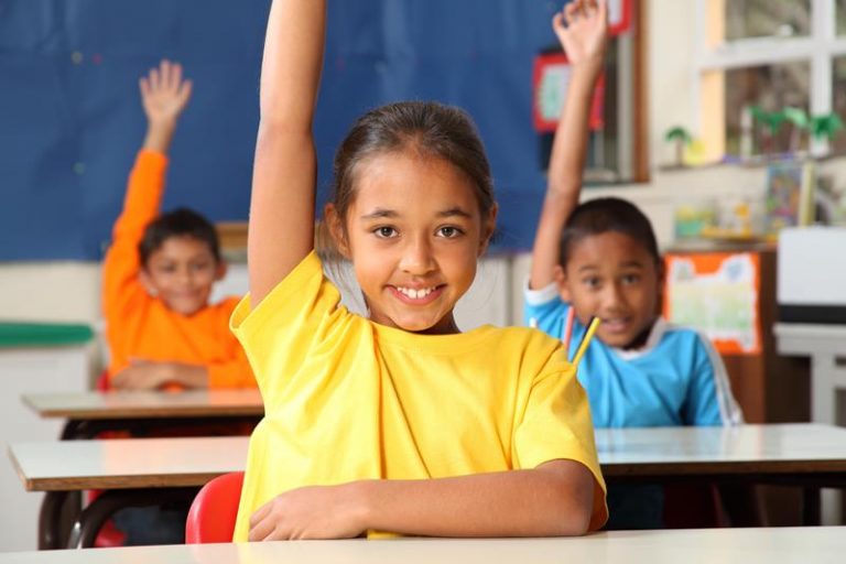 three school children raising their hands